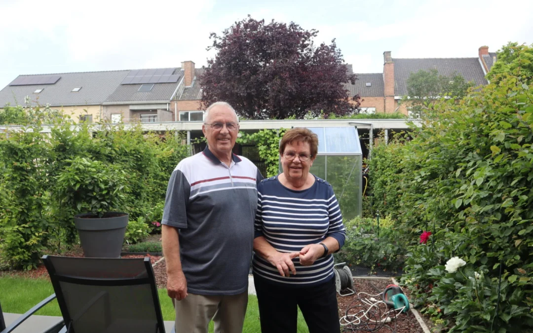 De bewoners Roland en Christine poserend in hun groene tuin.