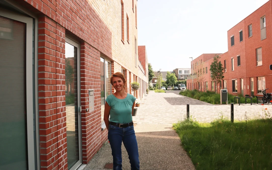 Bewoonster Isabelle poserend voor haar woning in de woonwijk Saffrou in Oudenaarde.
